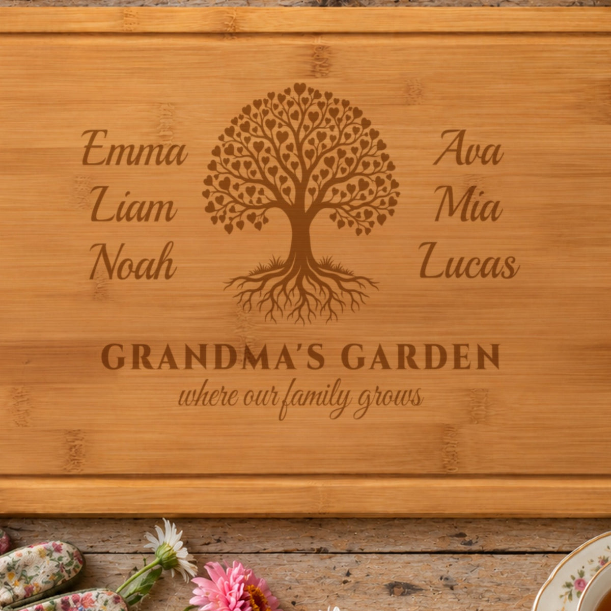 Close-up of the laser engraving on the grandma cutting board: Emma, Liam, Noah, Ava, Mia and Lucas around a family tree of tiny hearts