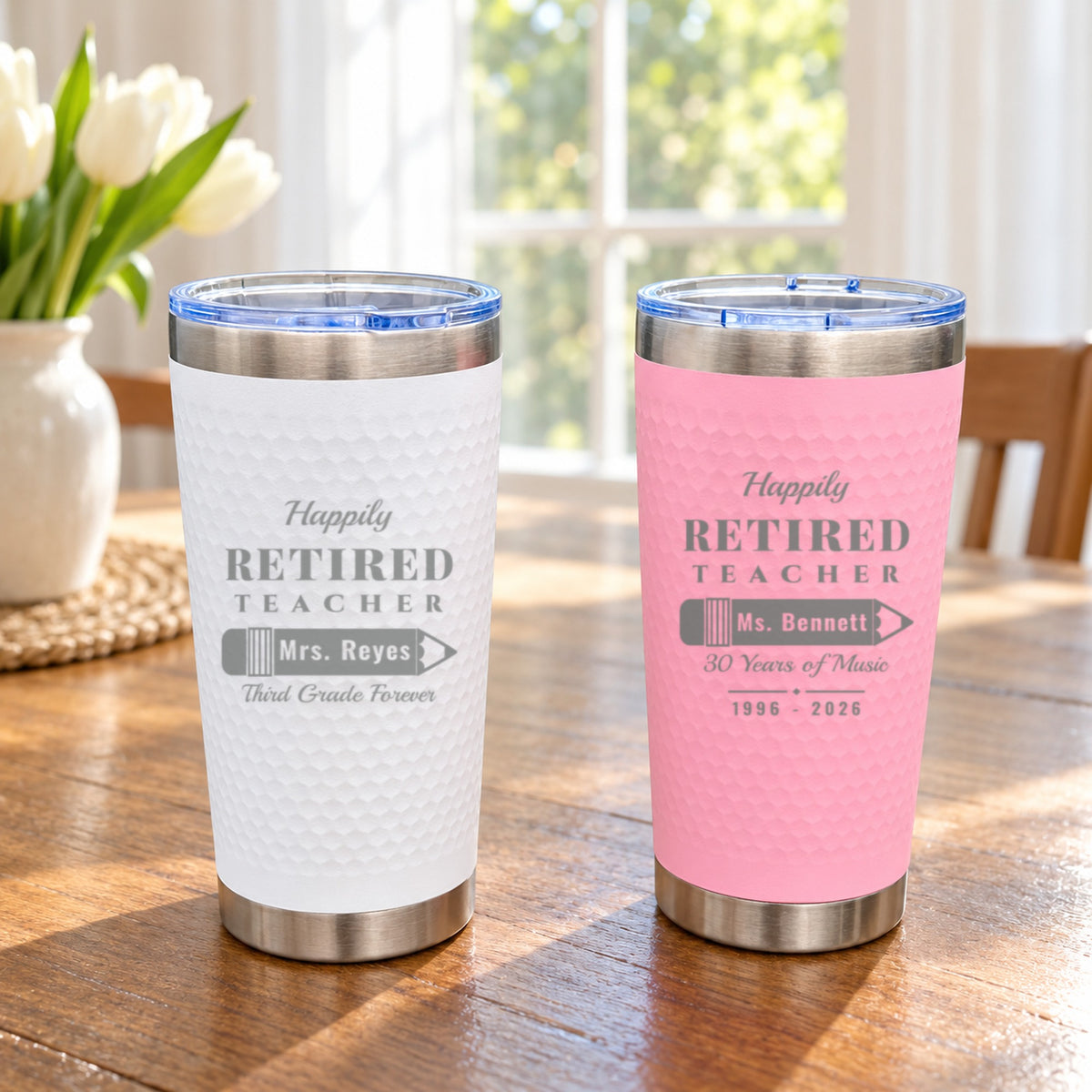 Pink and white Happily Retired Teacher tumblers engraved for Mrs. Reyes and Ms. Bennett, showing both color options side by side