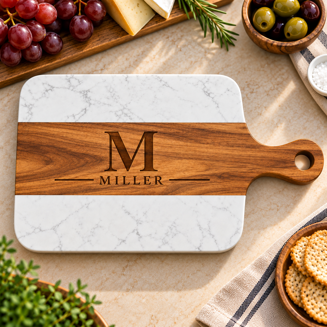 Personalized rectangular serving board with a white marble patterned top and lower section and a medium-brown wooden handle. The center wood band is engraved with a large letter M and the name MILLER.