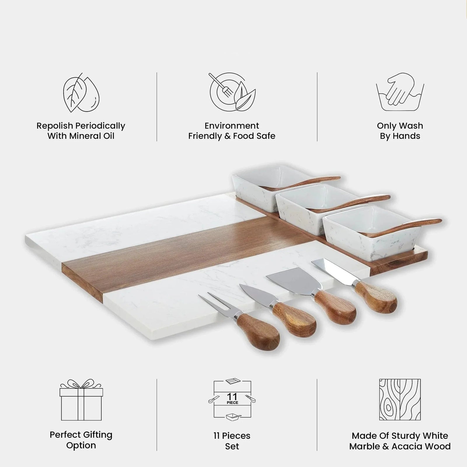 Eleven piece charcuterie set laid out, showing the marble and acacia board, three ceramic bowls, spoons and four utensils.