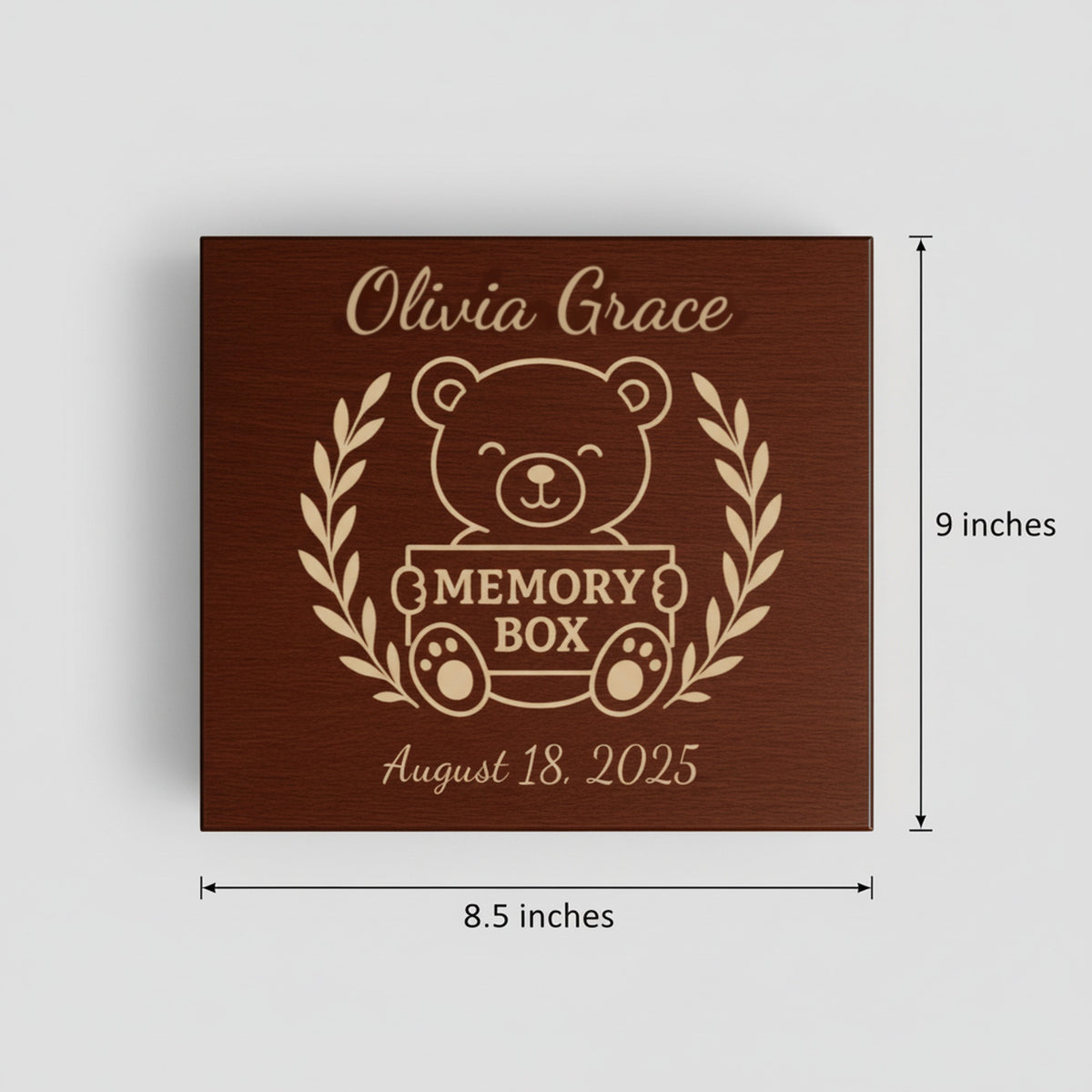 Engraved wood baby keepsake box lid shown with its measurements, 9 inches by 8.5 inches, featuring the teddy bear and laurel wreath design