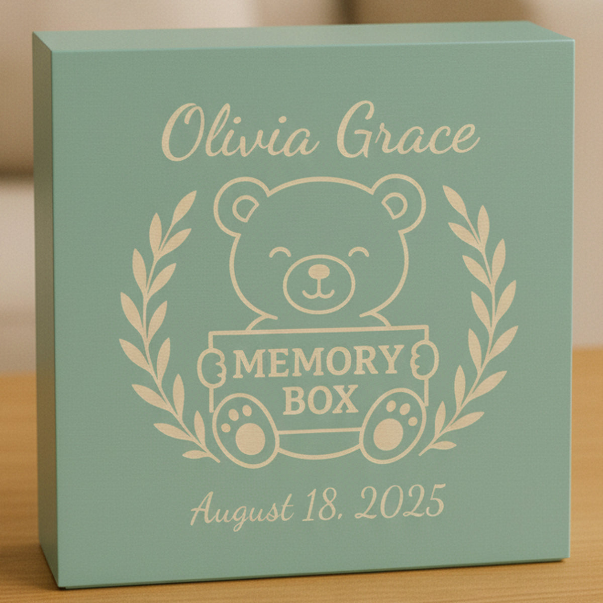 Teal personalized baby keepsake box engraved in tan with a teddy bear, laurel wreath, the sample name Olivia Grace and a birth date