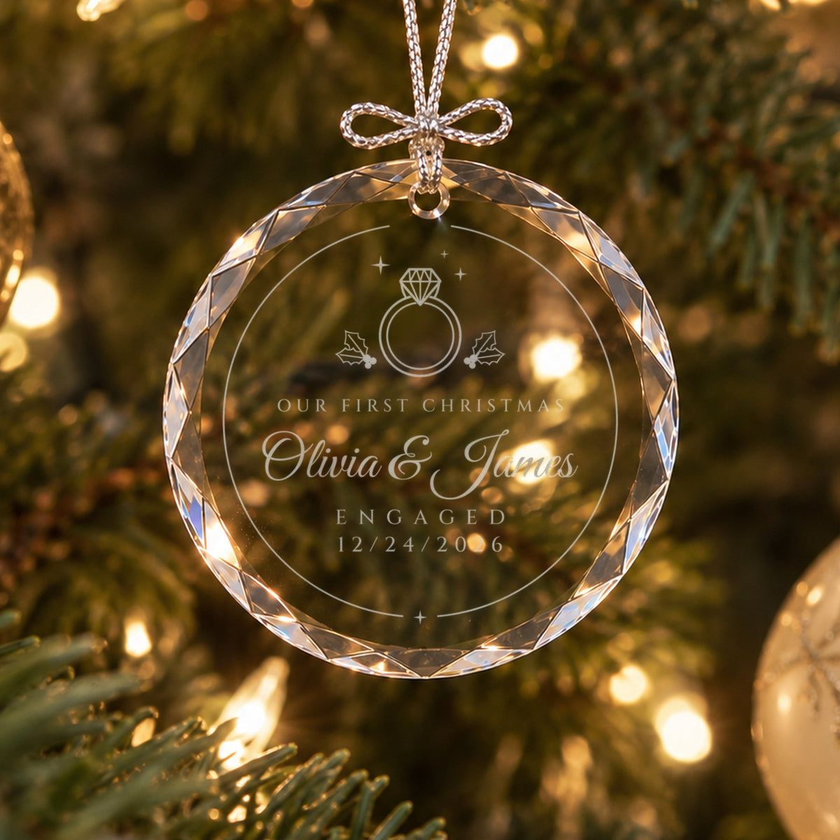 Personalized engagement ornament in faceted glass on a lit Christmas tree, engraved with a diamond ring, holly, Olivia &amp; James, ENGAGED 12/24/2026