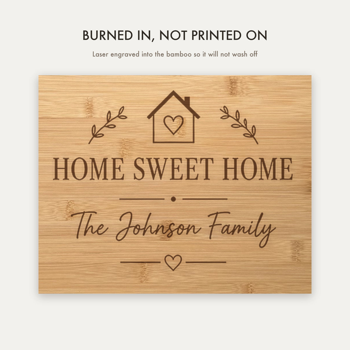 Close view of the laser engraving burned into the bamboo grain, showing the Home Sweet Home crest and the personalized family name in script.