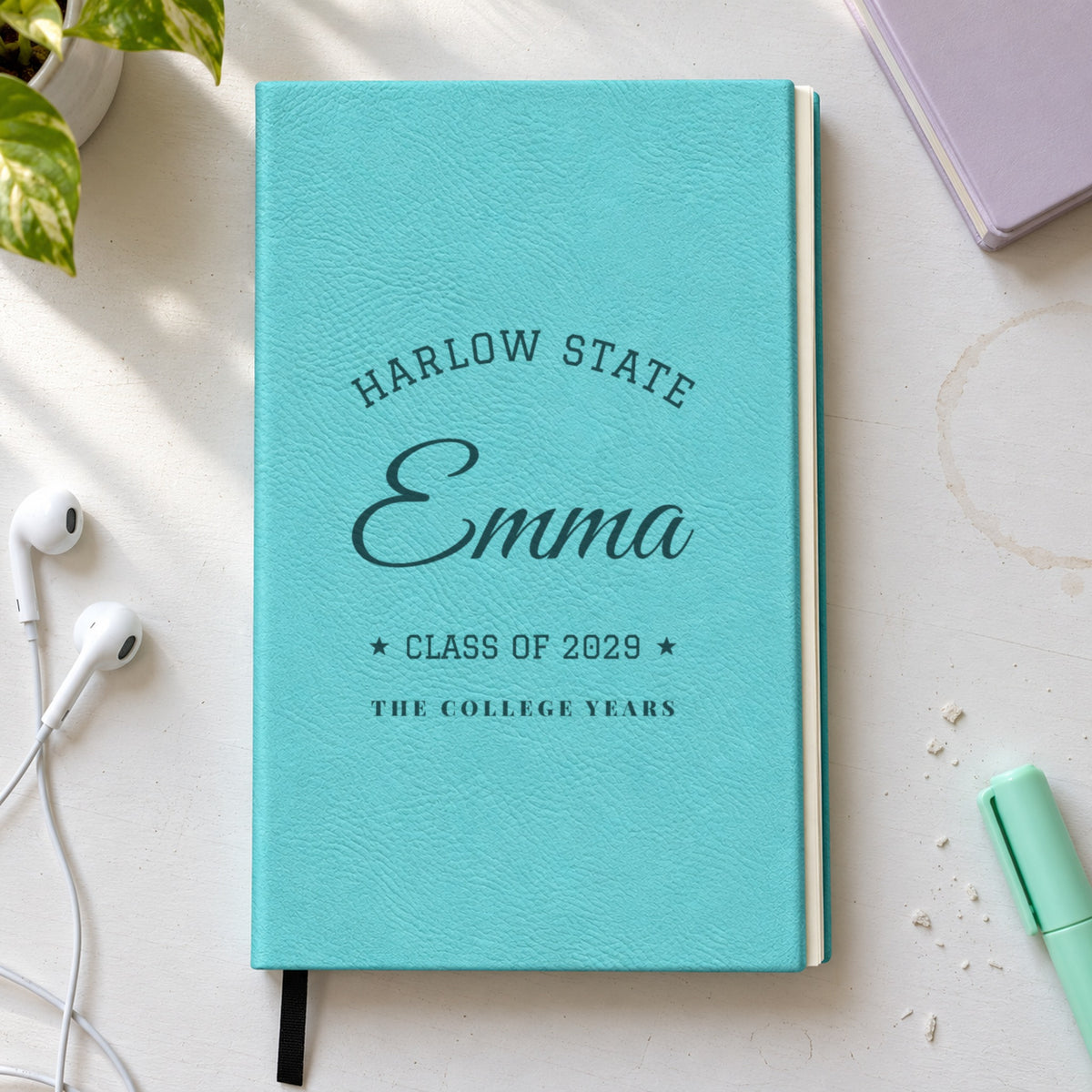 Personalized journal for a college girl in teal engraved with Harlow State arched over Emma in script, Class of 2029 and The College Years