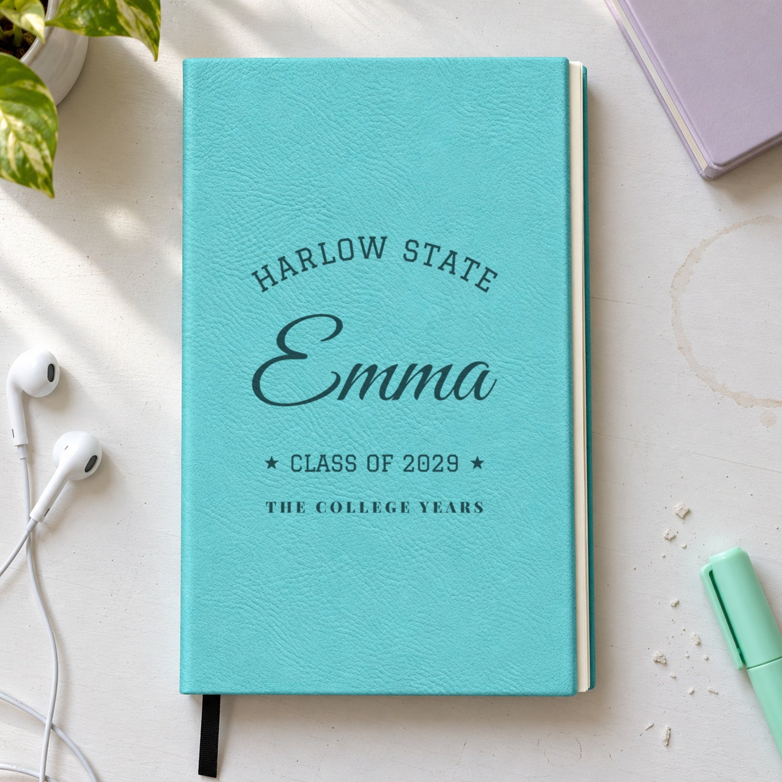 Personalized journal for a college girl in teal engraved with Harlow State arched over Emma in script, Class of 2029 and The College Years