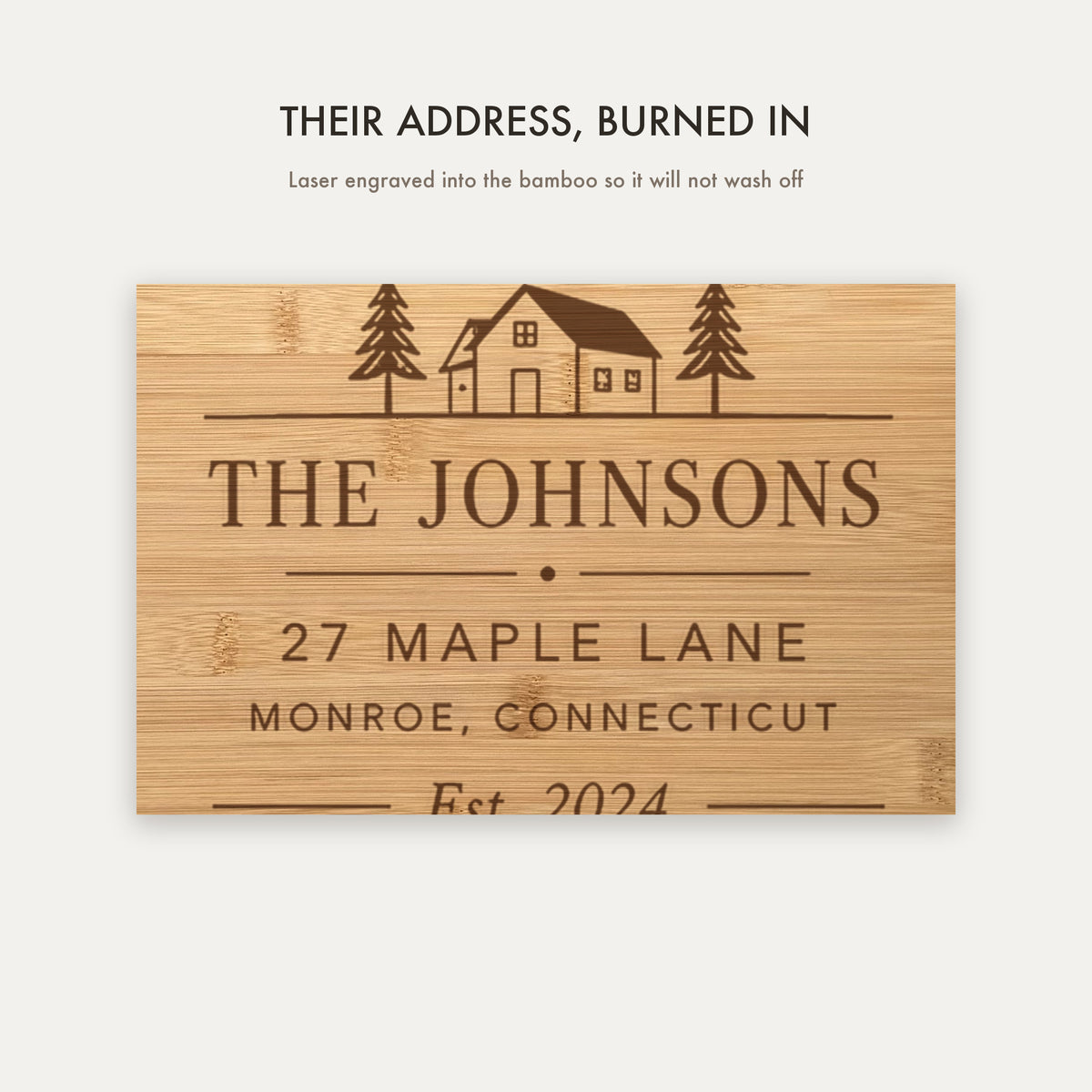 Close view of the laser engraving burned into the bamboo showing the house illustration, family name, street address, town and established year.