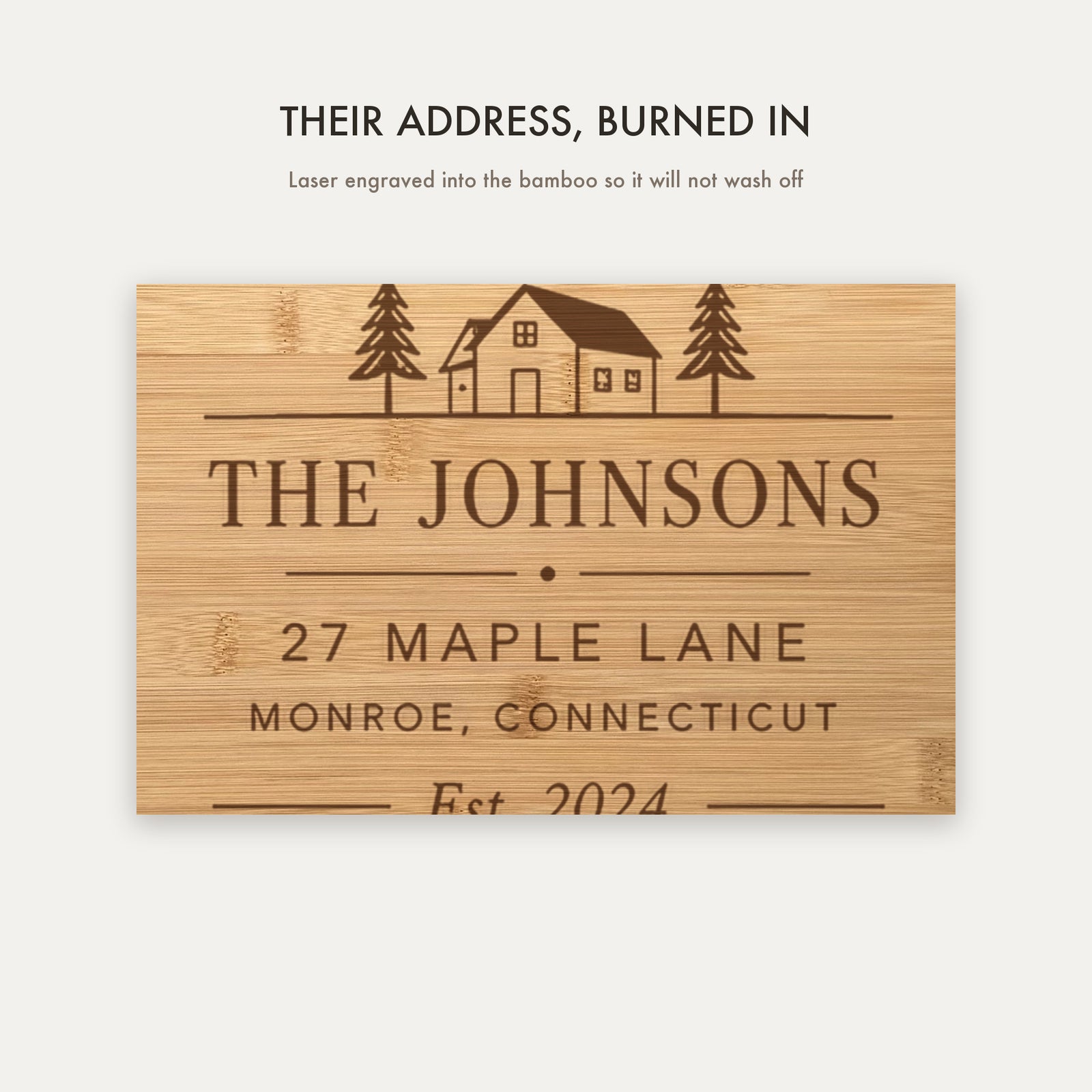 Close view of the laser engraving burned into the bamboo showing the house illustration, family name, street address, town and established year.