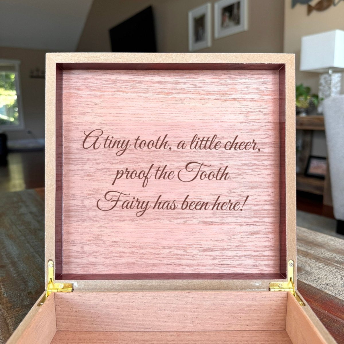 Inside lid of an open tooth fairy keepsake box engraved in script with the sample message A tiny tooth, a little cheer, proof the Tooth Fairy has been here