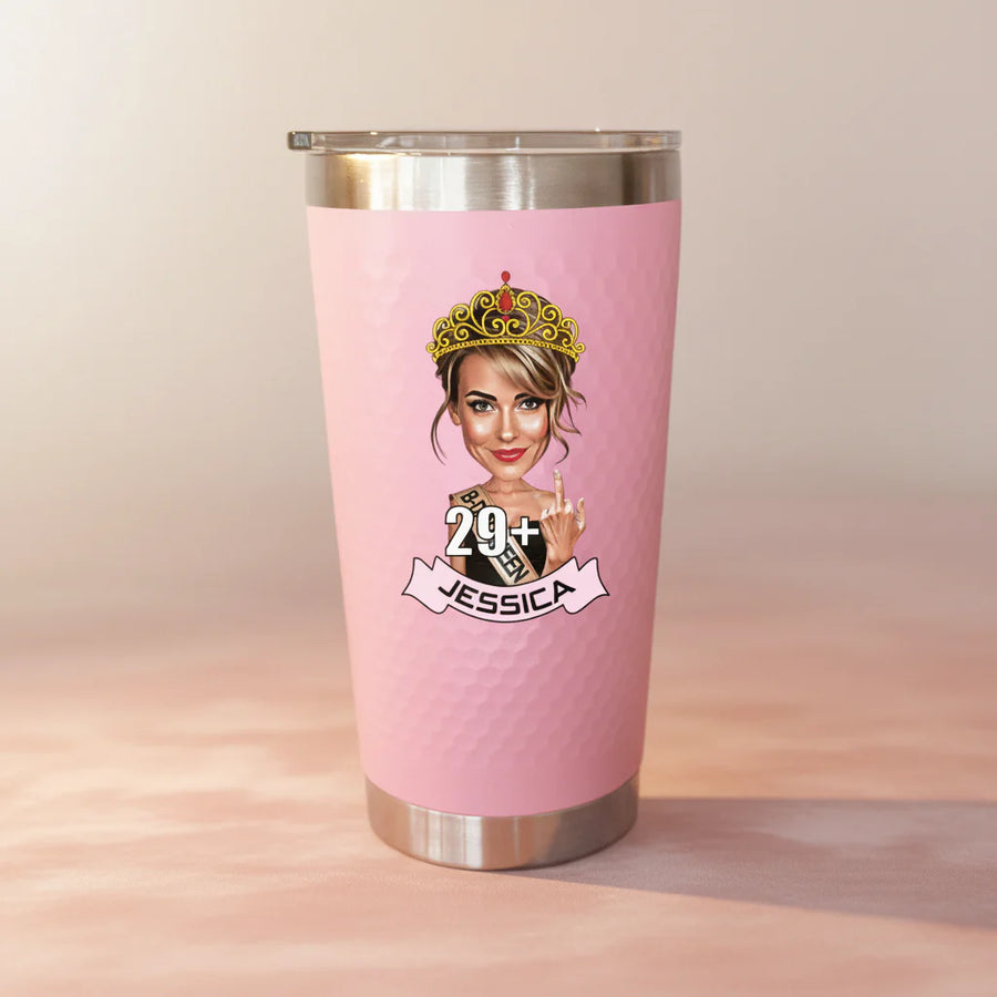 Pink insulated tumbler with stainless steel rim featuring a cartoon caricature of a woman wearing a golden crown, with sample name "JESSICA" and age "29+" printed below in a banner design