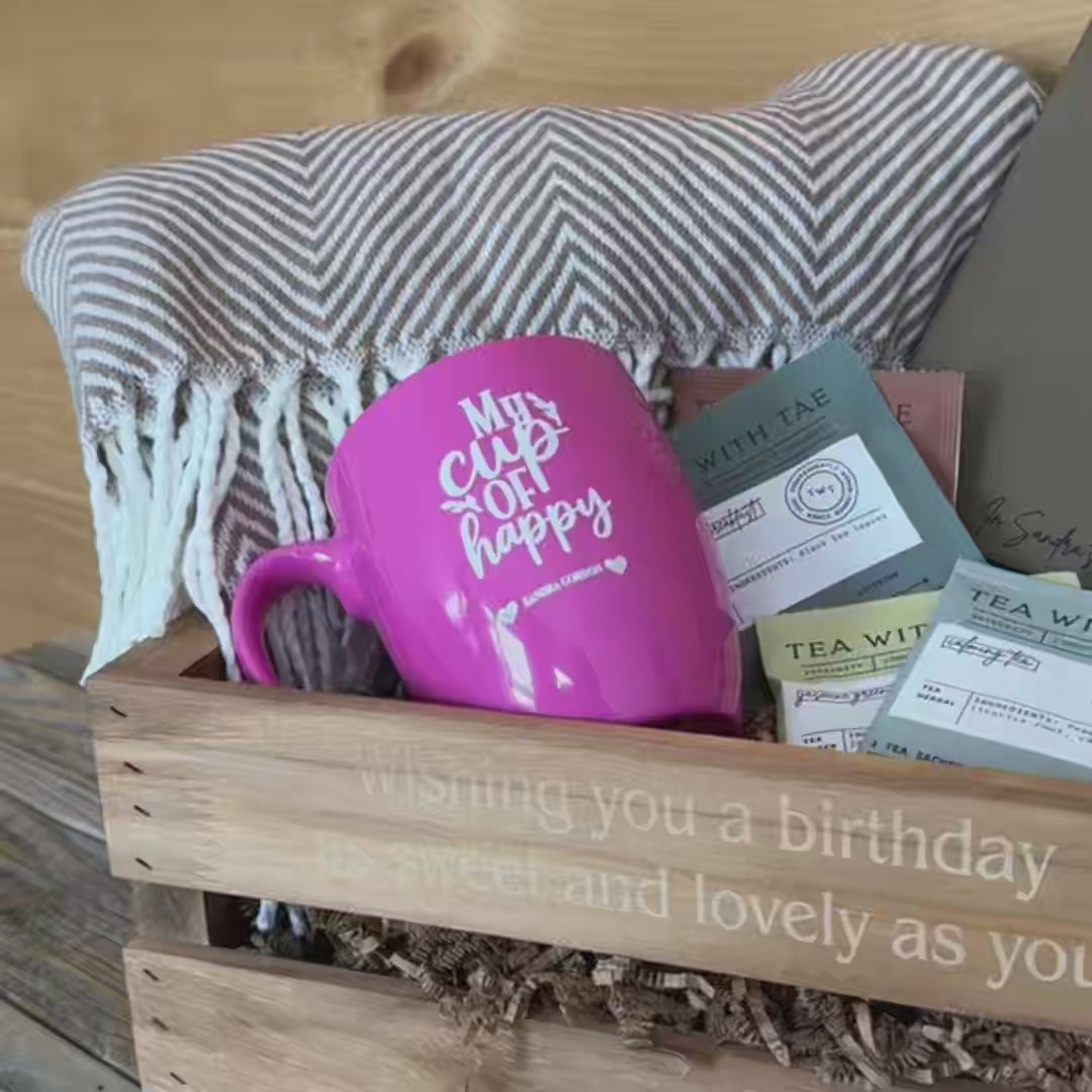 Cozy gift set with a soft throw blanket, personalized mug, premium teas, and a journal for relaxation.