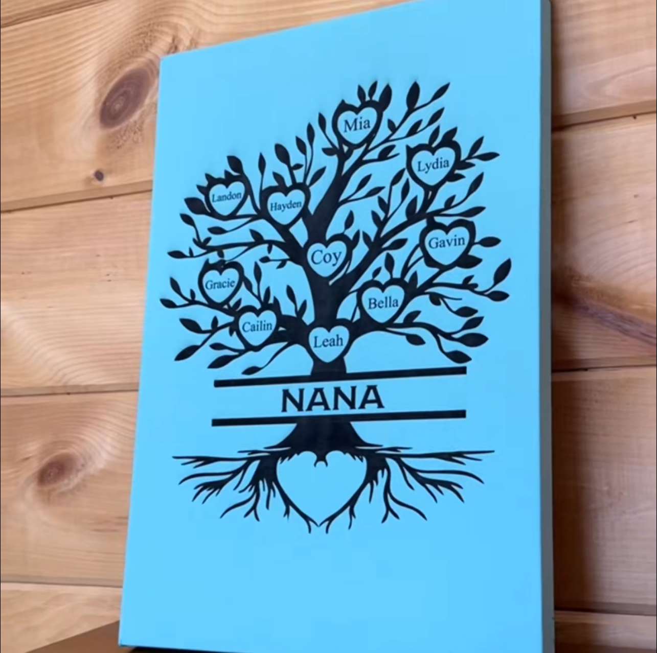 Personalized family tree sign with engraved names on a wooden plaque.