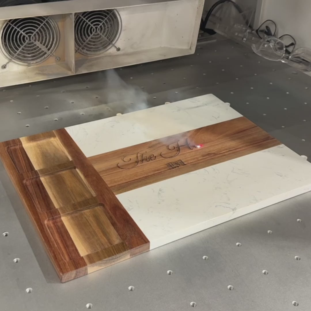 Video showcasing a personalized charcuterie board with marble and acacia wood, featuring included utensils and bowls.